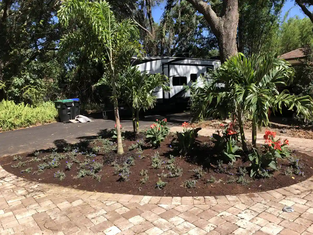 Circular planted island bed set into the paver driveway turnaround at a Winter Garden home