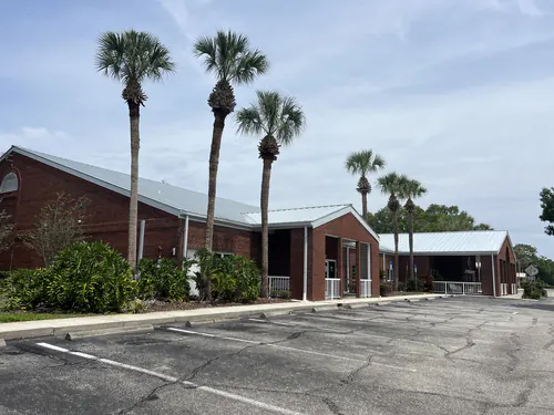 Clean parking lot and trimmed palms along the side of the Osceola County clinic