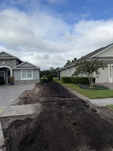 During: track loader marks across the stripped front yard with the old turf removed