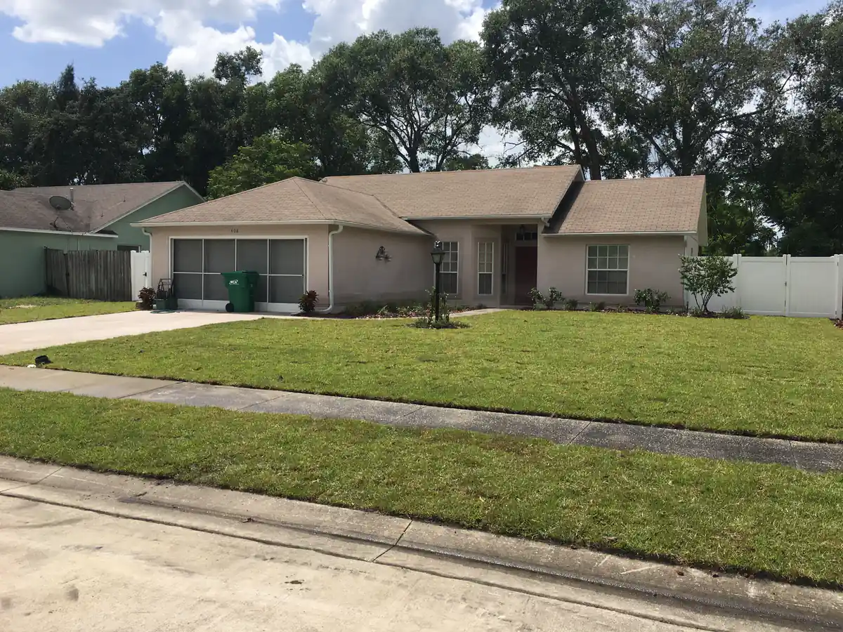 The finished DeLand front lawn filled in green and edged along the driveway and sidewalk