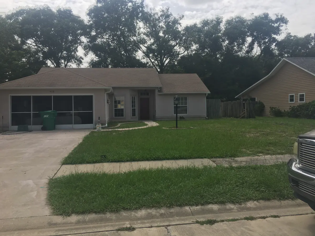 Patchy weed filled front lawn at a DeLand ranch home before the old turf was stripped out